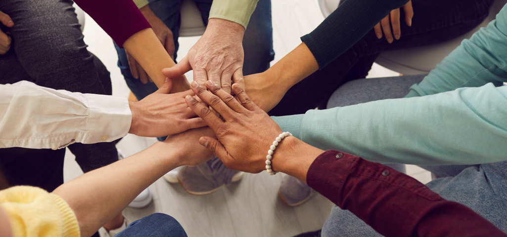 Seven hands on top of each other to represent a team