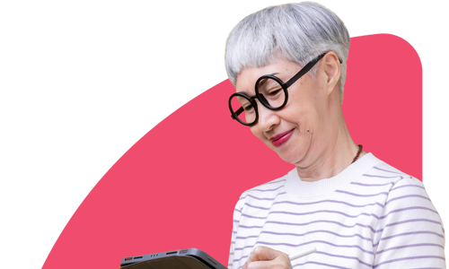 A woman looking at a tablet on a pink background