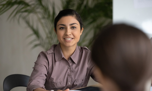 Woman sitting across desk from customer giving advice 