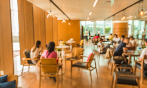 People sitting at tables in an indoor community space