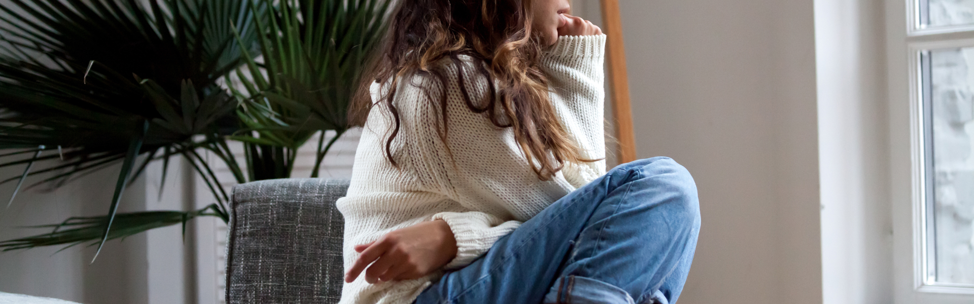 Young woman sat on a chair looking out of the window