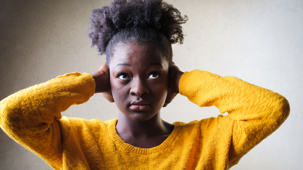 A woman holding her hands over her ears. 