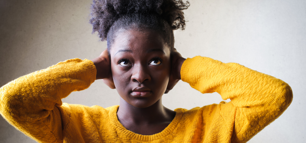 A woman holding her hands over her ears.