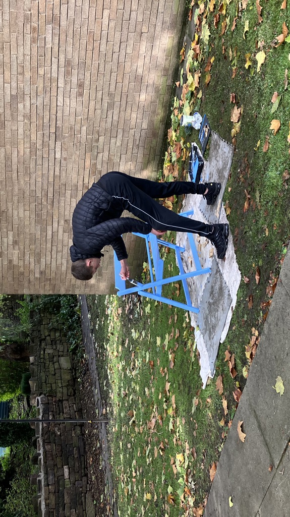 A man painting a blue chair outside 