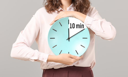 A woman holding a clock that shows 10 minutes countdown