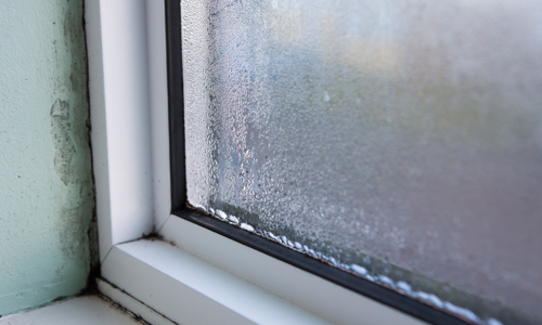Condensation around a window with black mould around the seal