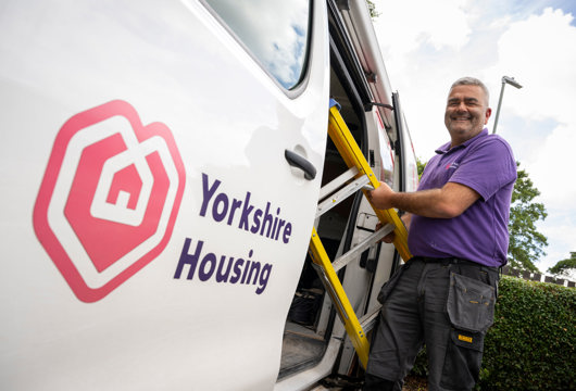 Colleague standing next to Yorkshire Housing van with a ladder
