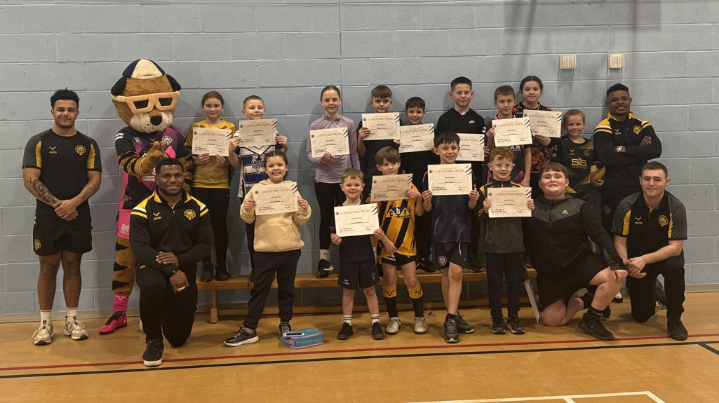 A group photo of players, coaches and youngsters holding certificates at the Castleford Tigers camp.