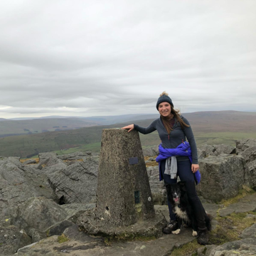 Sian climbing with her dog, reaching the peak