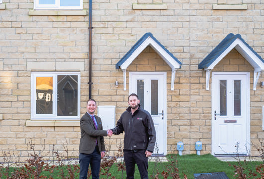 Joel Frank, Land Director at Charles Church Yorkshire shaking hands with Ed Blake, Land Buyer at Yorkshire Housing, at the Harrogate Harlow Hill development.