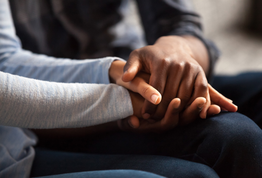 A person taking the hand of someone else to support them