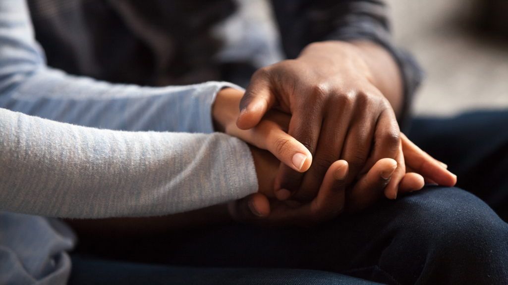 A person taking the hand of someone else to support them